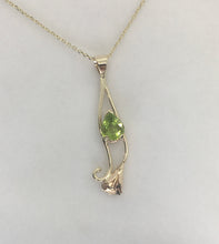 Load image into Gallery viewer, Btrght green teardrop shape peridot t set in a gold calla lily design, on a square cable chain,  lobster claw clasp.