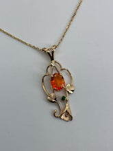 Load image into Gallery viewer, reddish orange oval opal with a small green garnet in a 14Kg pendant with leaves, vines and a lilly
