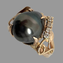 Load image into Gallery viewer, 14K yellow gold ring featuring a large, lustrous black pearl as the center stone, accented by a row of small diamonds on one side and a cala lilly on the other side..