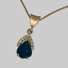 Load image into Gallery viewer, 14K yellow gold prong set deep blue sapphire with 9 diamonds in a wishbone shape at its top.