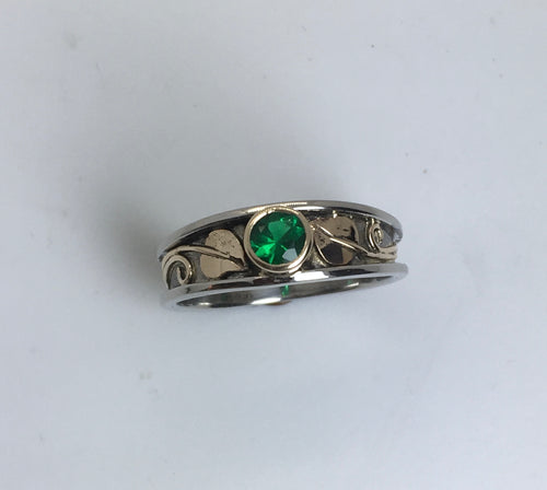 sparkly round bezel emerald with gold leaves platinum band