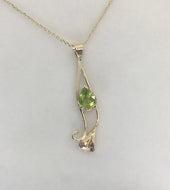 Btrght green teardrop shape peridot t set in a gold calla lily design, on a square cable chain,  lobster claw clasp.
