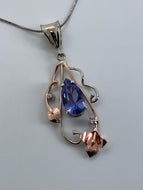 airy large pears-haped tanzanite surrounded by 14K rose & white gold flower & vines