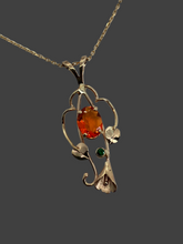 Load image into Gallery viewer, beautful oval orange Mexiican fire opal with green Tsavorite garnet in 14Kg pendant with leaves, vines and a lilly
