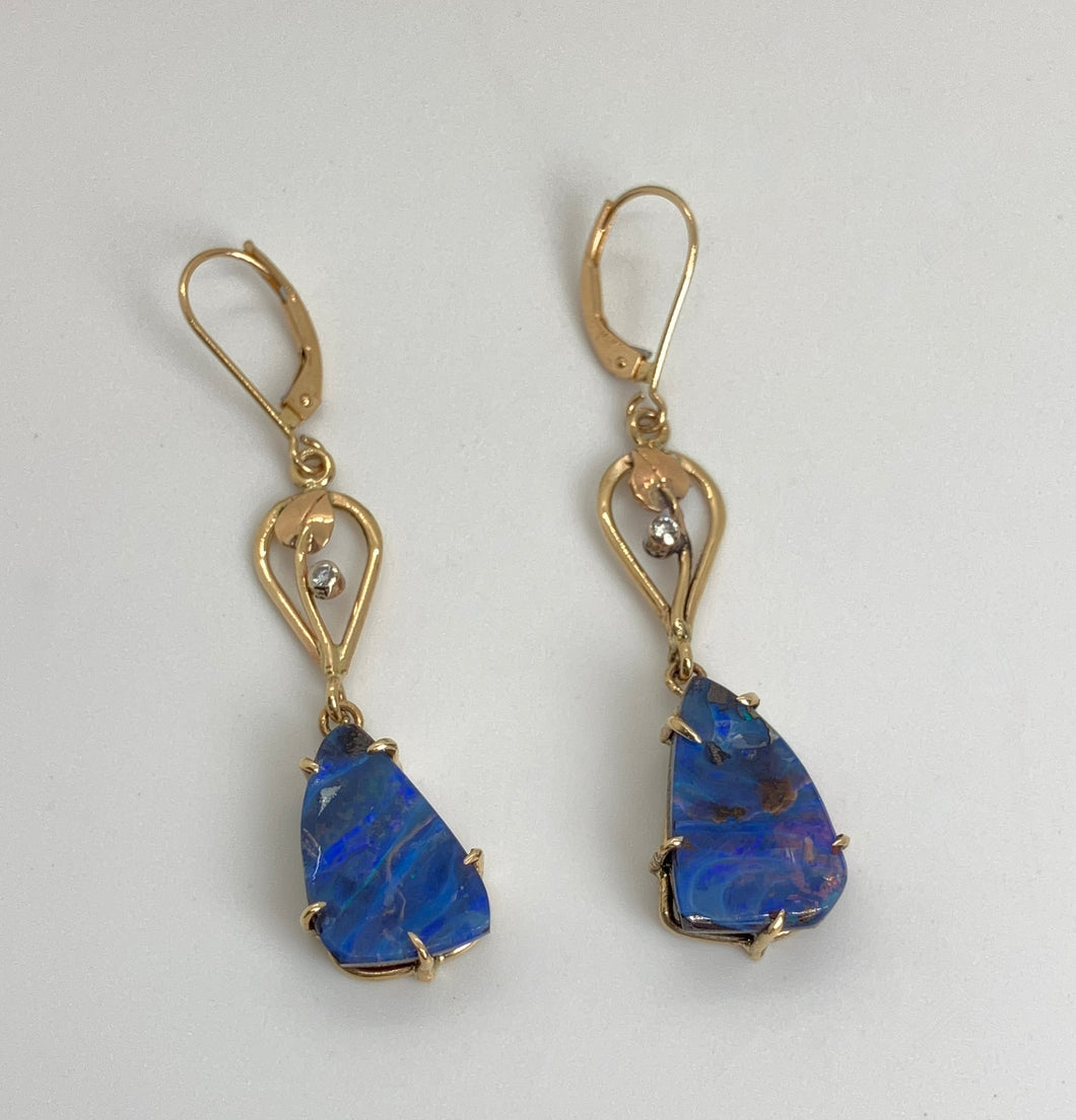 Free form triangular Boulder Opals from Queensland, Australia are held with custom-made prongs. They hang below handmade leaf & vine motif teardrops, each with a small bezel set, recycled Diamond