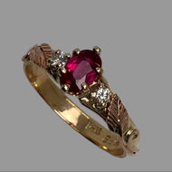 Ring with oval-shaped ruby, yellow gold prongs and rose gold leaves, featuring diamonds on the sides