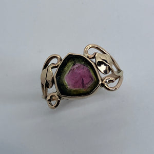 pink and green tourmaline in a 14K gold ring featuring leaves and swirls 