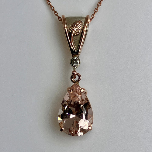 Rose gold necklace with a teardrop-shaped Morganite with a rose and white gold bail on a rose gold chain
