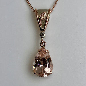 Rose gold necklace with a teardrop-shaped Morganite with a rose and white gold bail on a rose gold chain