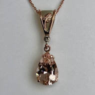 Rose gold necklace with a teardrop-shaped Morganite with a rose and white gold bail on a rose gold chain
