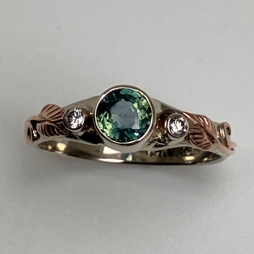 white and rose 14K gold ring with round  teal sapphire, 2 diamonds and 2 leaves and vines