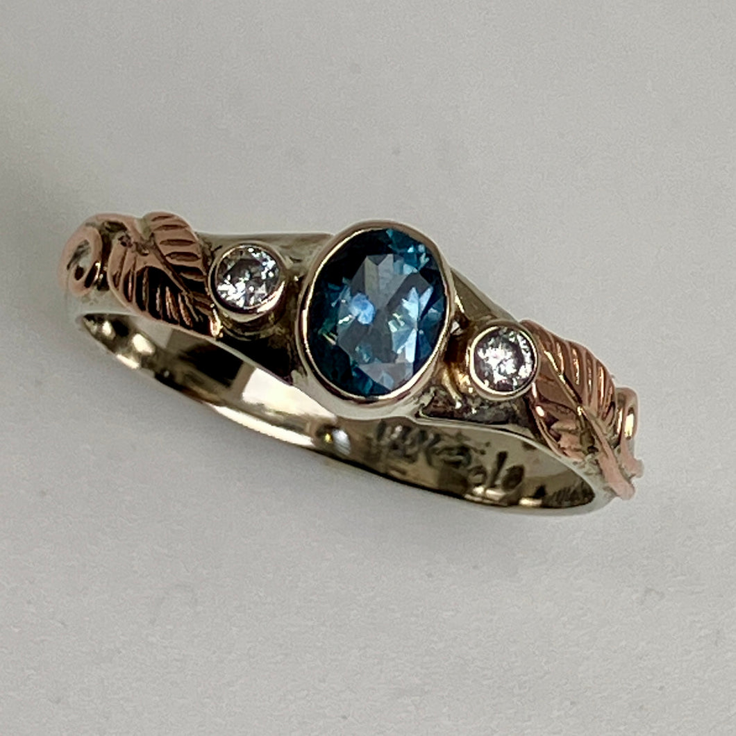 14K white gold ring with oval teal blue Montana Sapphire and diamonds with 14K rose gold leaves and vines