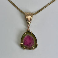 pendant with organic shape slice of watermelon tourmaline has red center and green rind.