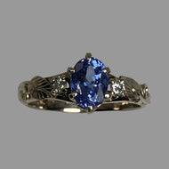 14K white gold Rrng with a blue/purple Tanzanite, diamonds and leaves and vines.