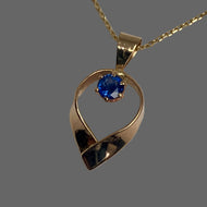 pendant necklace featuring a faceted open teardrop design with a round bright blue Ceylon Sapphire at the center, suspended from a square cable chain , all 14K yellow gold