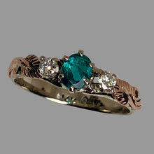 Load image into Gallery viewer, Trichroic blue/green/yellow oval center gemstone set with a pair of round diamonds and rose gold leaves in a white gold band.
