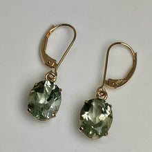 Load image into Gallery viewer, Soft green colored oval gems set with 14K yellow gold prongs and earwires that snap shut.
