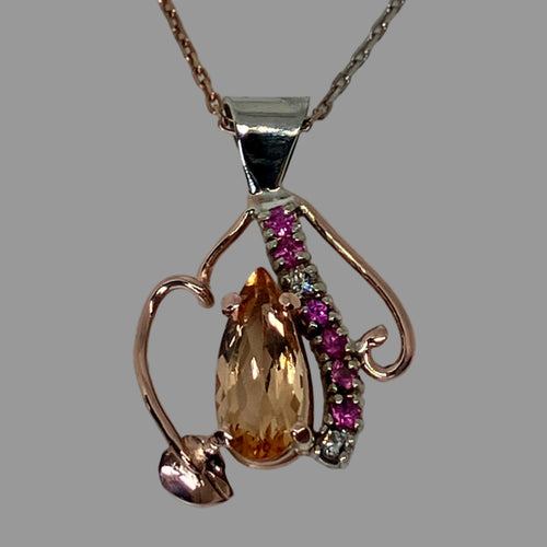 14K rose gold pendant with a central Imperial Topaz, 6 pink sapphires and 2 diamonds with leaf and vine