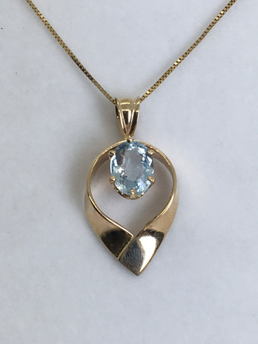 Radiant aquamarine embraced by gold pendant