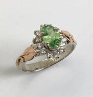 oval mint green Garnet ring with halo of diamonds in a white gold  band and  rose gold ivy leaf and tendrils